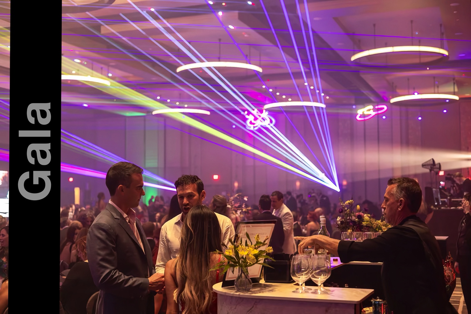 Guests chatting at the bar beneath colorful laser beams at the Amanda Hope gala